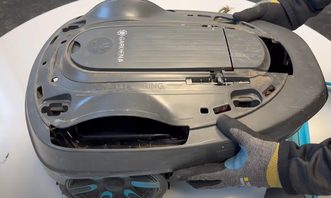 Sätter fast kåpan på en robotgräsklippare